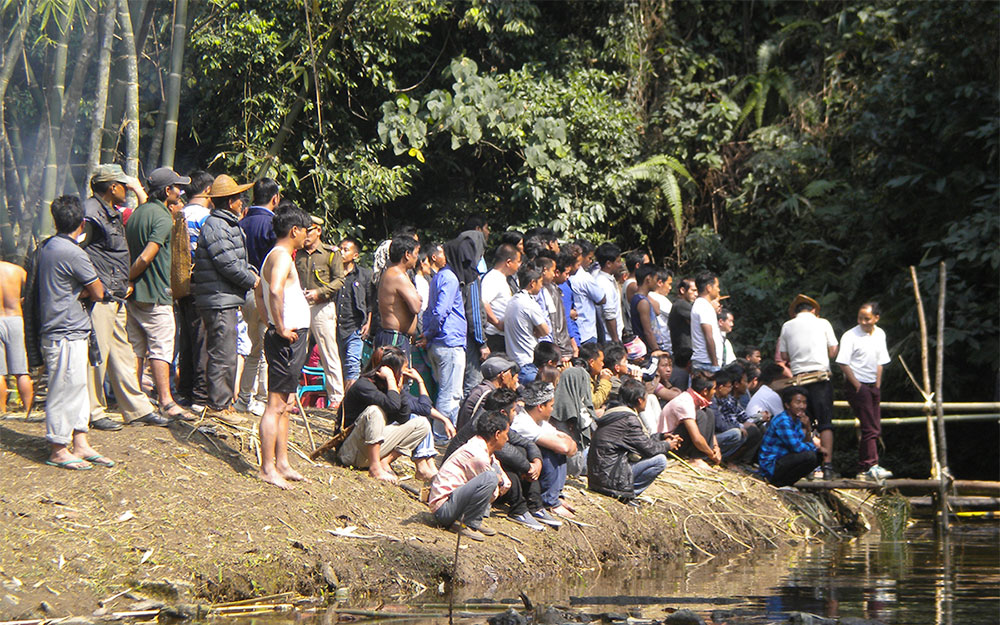 Basar residents gather around an area to witness the traditional fish catching ceremony